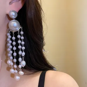 Close-up macro view of elegant vintage pearl tassel drop earrings with silver needles