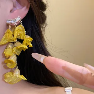 Detailed view of elegant yellow chiffon flower tassel earrings with sparkling zircon studs.