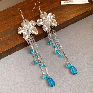 Dettaglio degli orecchini a fiore d'argento con nappe in cristallo blu a cascata