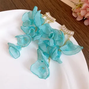 Close-up detail of blue chiffon flower tassel earrings featuring shiny zircon studs