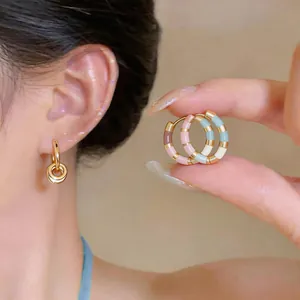 Close-up of 14K gold plated dopamine colorful striped enamel hoop earrings on model.