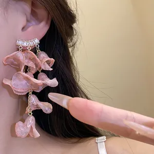 Close-up of elegant pink chiffon flower tassel earrings with clear zircons on model's ear