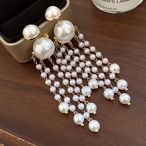 Detailed view of elegant white pearl tassel earrings with gold-tone hardware.