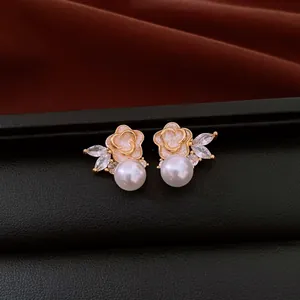 Detailed view of elegant flower stud earrings featuring white pearls and marquise stones