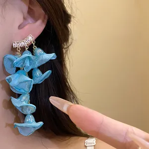 Detail of elegant blue chiffon flower tassel earrings with zircon studs