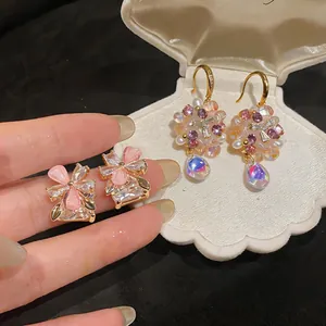 Detailed macro shot of colorful crystal flower earrings displayed in a shell box.