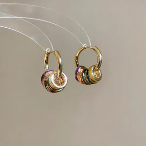 Macro detail of 14K gold plated hoop earrings featuring vibrant dopamine colored enamel rings