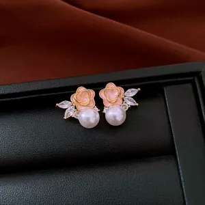 Detail shot of elegant pink enamel flower earrings with pearl and marquise zircon accents.
