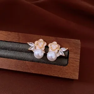 Close-up view of vintage floral pearl stud earrings featuring sparkling zirconia accents