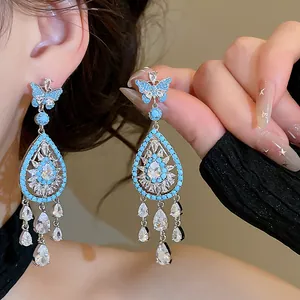 Close-up detail of luxury blue zircon butterfly earrings with cascading crystal drops.