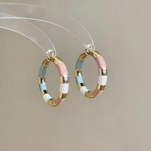 Detail view of 14K gold plated hoop earrings with colorful enamel splicing sections