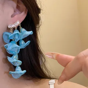 Detail view of blue chiffon flower tassel earrings featuring shiny zircon studs.