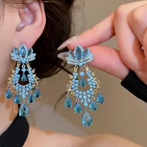 Detailed view of exquisite blue zircon lotus flower dangle earrings with teardrop crystals