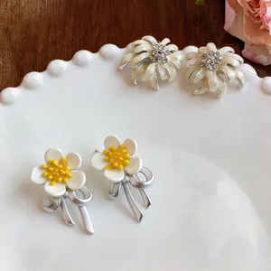Detailed view of floral earrings with oil-drop petals and sparkling crystals.
