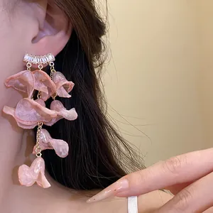 Detailed close-up showing pink chiffon flower tassel earrings with shiny zircon accents