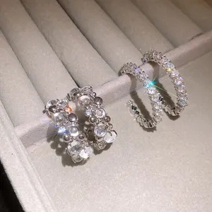 Close-up of sparkling zircon C-shape hoop earrings in a velvet jewelry box