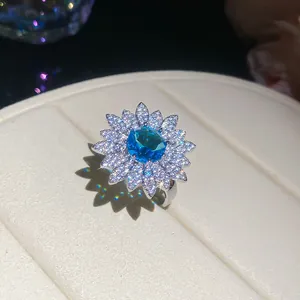 Close-up of elegant flower ring with vibrant blue zircon and sparkling stones