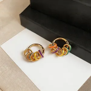 Close-up of 14K gold plated dopamine style earrings with colorful enamel charms