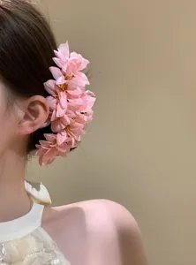 Elegante fermaglio per capelli con fiori di stoffa rosa su acconciatura da donna