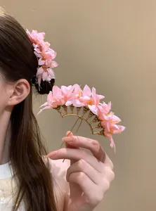 Dettaglio del fermaglio per capelli con fiori di stoffa rosa per acconciature cinesi.