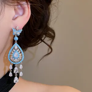 Close-up of elegant blue butterfly dangle earrings with sparkling zircon teardrops.