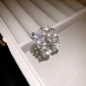 Macro close-up of luxury silver C-shaped earrings with sparkling zircons and resin beads
