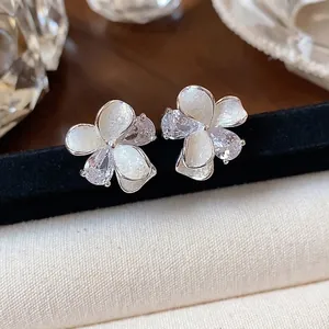 Elegant white enamel flower stud earrings with sparkling zircon accents and silver needle base