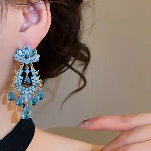 Close-up detail of exquisite heavy blue zircon flower drop earrings on ear