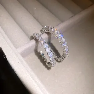 Elegant macro detail of sparkling zircon C-shaped hoop earrings in a velvet box.