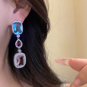 Close-up view of elegant tri-color zircon dangle earrings featuring vintage crystal accents.