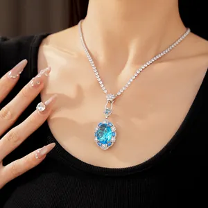 Detail view of an elegant silver-tone necklace with a large oval blue zircon pendant.