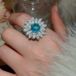 Close-up detail of a sparkling blue zircon sunflower ring worn on a hand with luxury feel