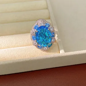 Detailed close-up view of an exquisite oval blue zircon ring in a beige velvet display box