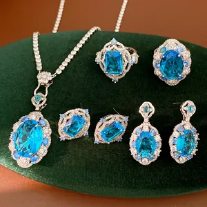 Exquisite blue zircon jewelry set including oval necklace, rings, and earrings on velvet.