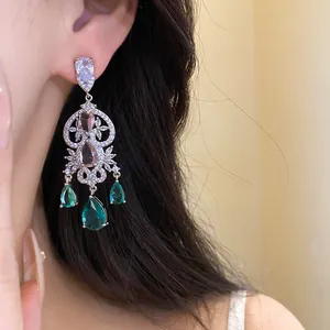 Detailed shot of emerald green teardrop chandelier earrings with clear zircon accents