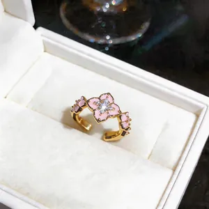 Close-up detail of 18K gold plated ring with pink enamel flower and zircon