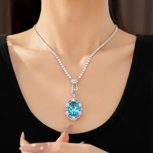 Close-up view of an elegant oval blue zircon pendant necklace featuring a tennis chain design