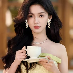 Elegant model wearing exquisite cream yellow flower tassel earrings in a garden.