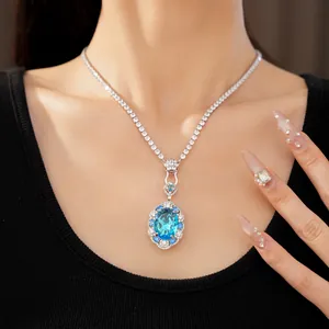 Close-up view of an elegant oval blue zircon pendant necklace with silver tennis chain