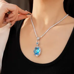 Elegant detail view of a luxury oval blue zircon pendant necklace worn by a model