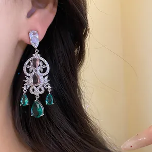 Detailed macro shot of elegant silver drop earrings featuring green zircon teardrop stones