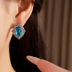 Macro detail of elegant earring featuring an emerald-cut blue zircon and silver setting
