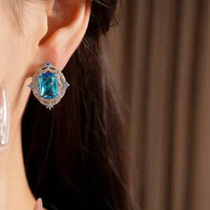 Close-up detail of luxury vintage blue zircon stud earrings worn on a model's ear