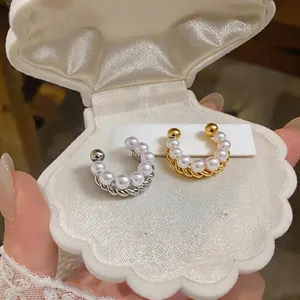 Close-up detail of elegant French style pearl beaded ear cuffs presented in a shell box