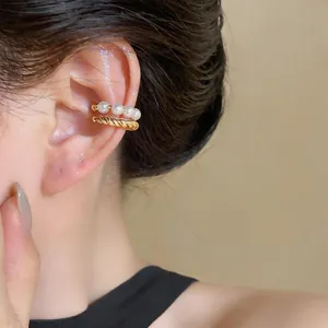 Detailed close-up view of an elegant double-layered gold ear cuff with white pearls