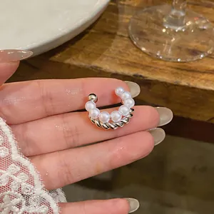 Close-up detail of double-layer ear cuff featuring white pearls and twisted silver band.