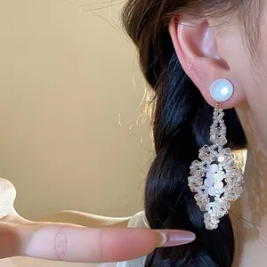 Primer plano de elegantes pendientes de plata estilo bosque con cristales de diamante puro