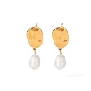 Close-up of elegant vintage gold hammered metal earrings with Baroque drop pearls