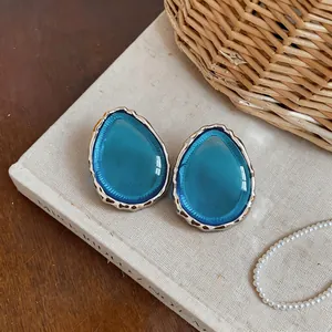 Vista dettagliata di eleganti orecchini a goccia in resina blu con bordi in argento