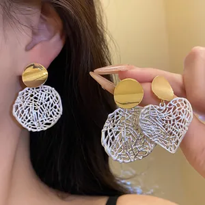 Detailansicht von hohlen Herz-Ohrhängern im Vintage-Stil in Gold- und Silberoptik